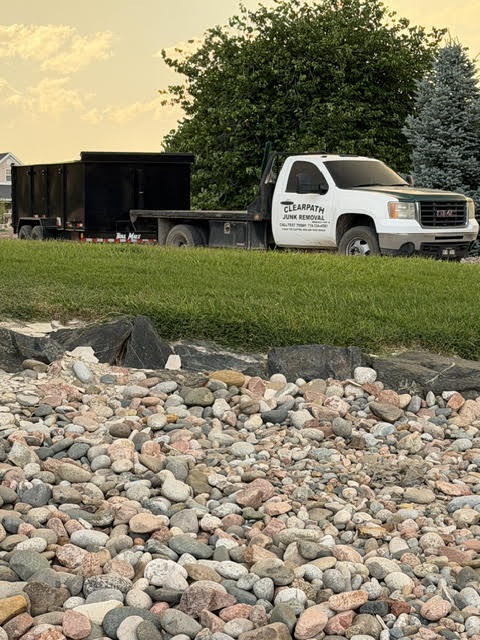 ClearPath junk removal truck and 7-ton dump trailer parked at a Pueblo West home